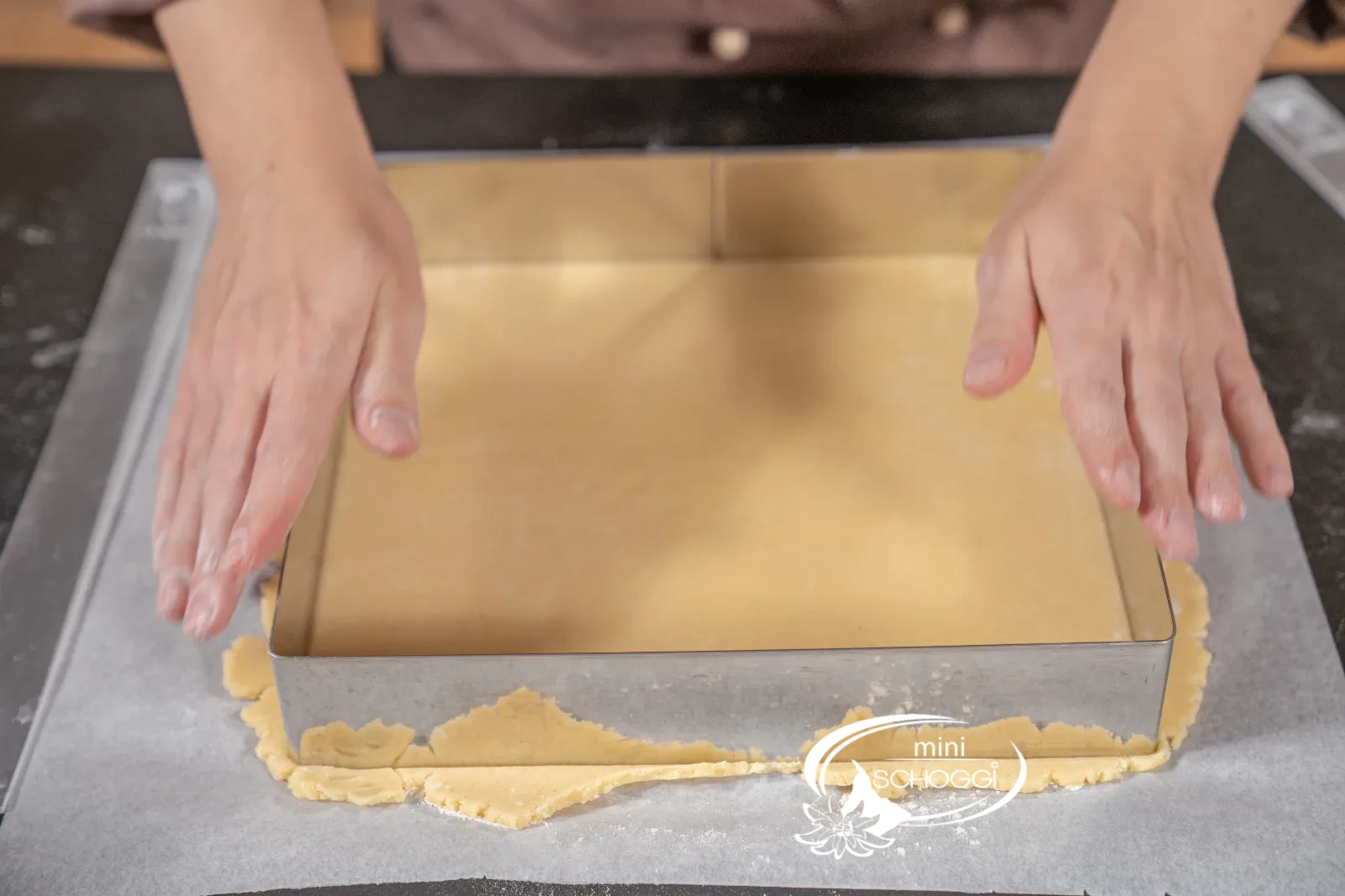 Le cercle à tarte carré découpe la plaque de pâte