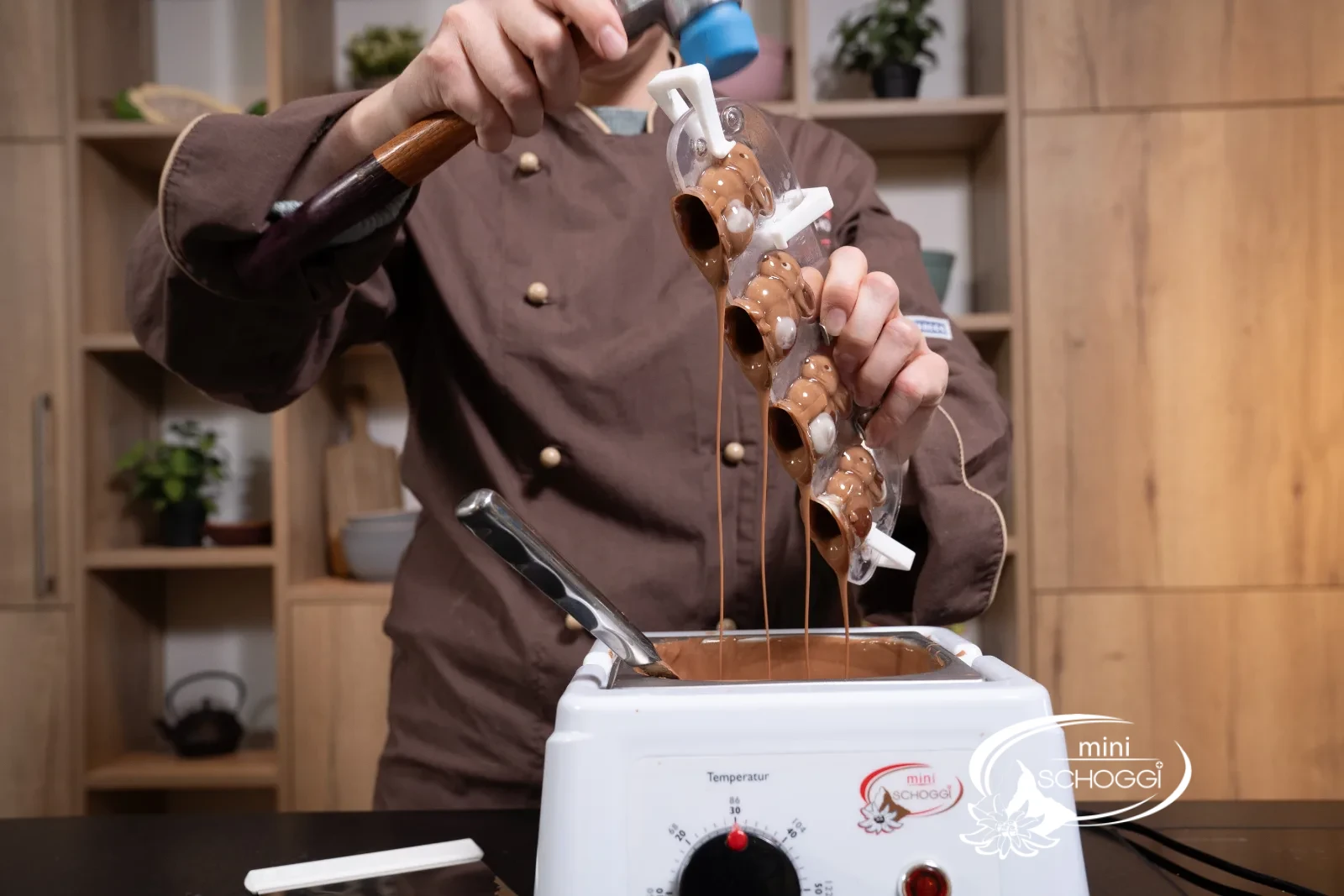 Lo stampo viene riempito con copertura di cioccolato sopra la temperatrice