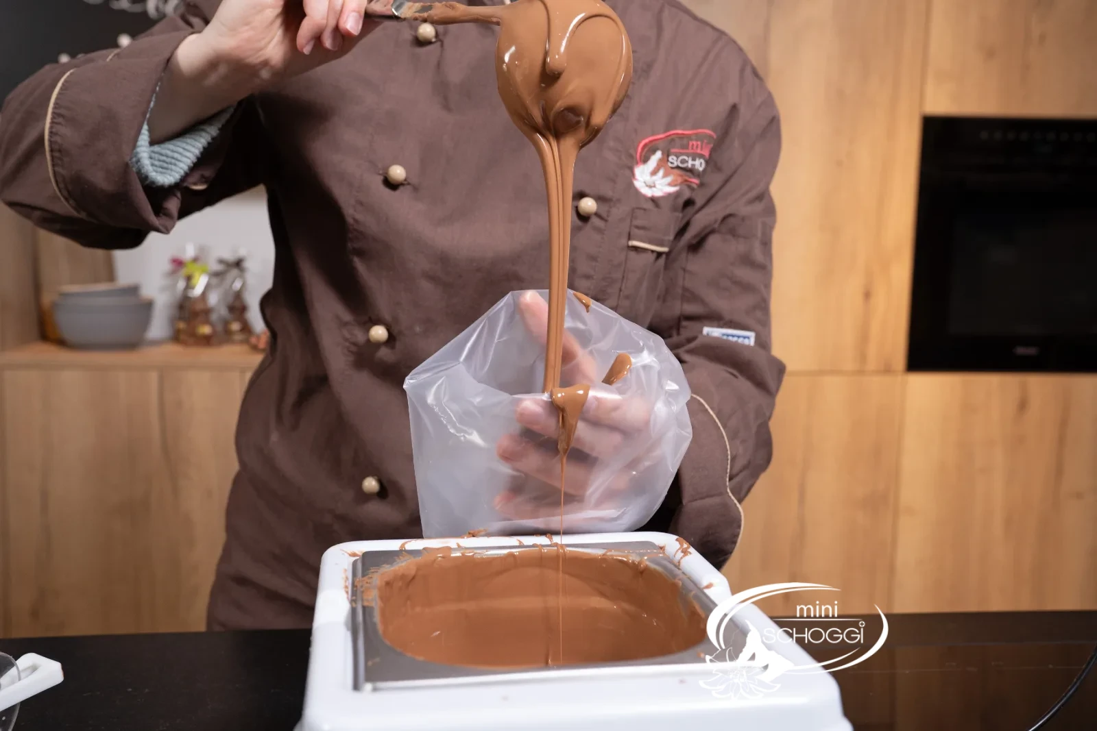 La copertura di cioccolato temperata viene messa nel Sac à poche
