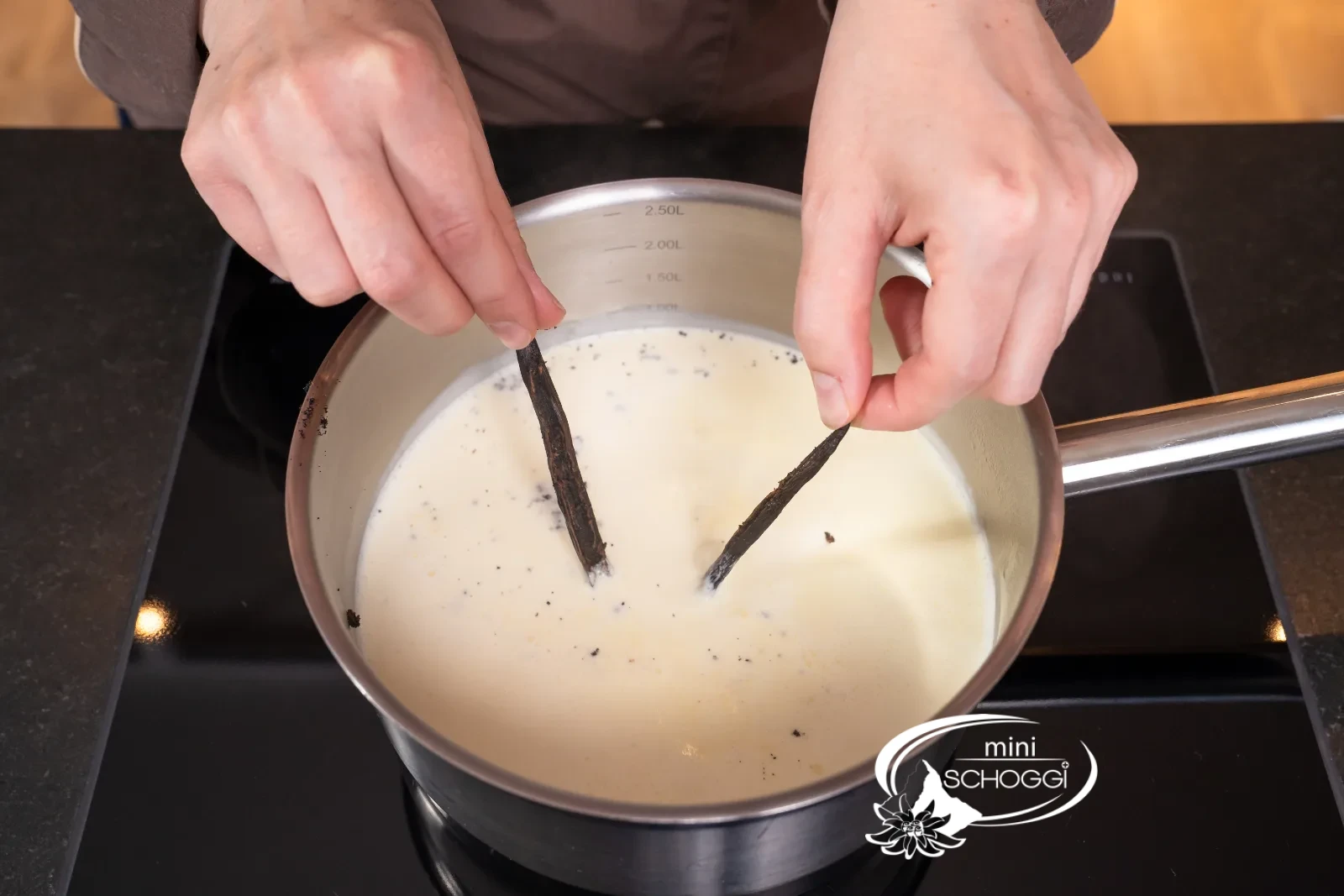 La crème entière, le lait et les gousses de vanille frémissent dans la casserole