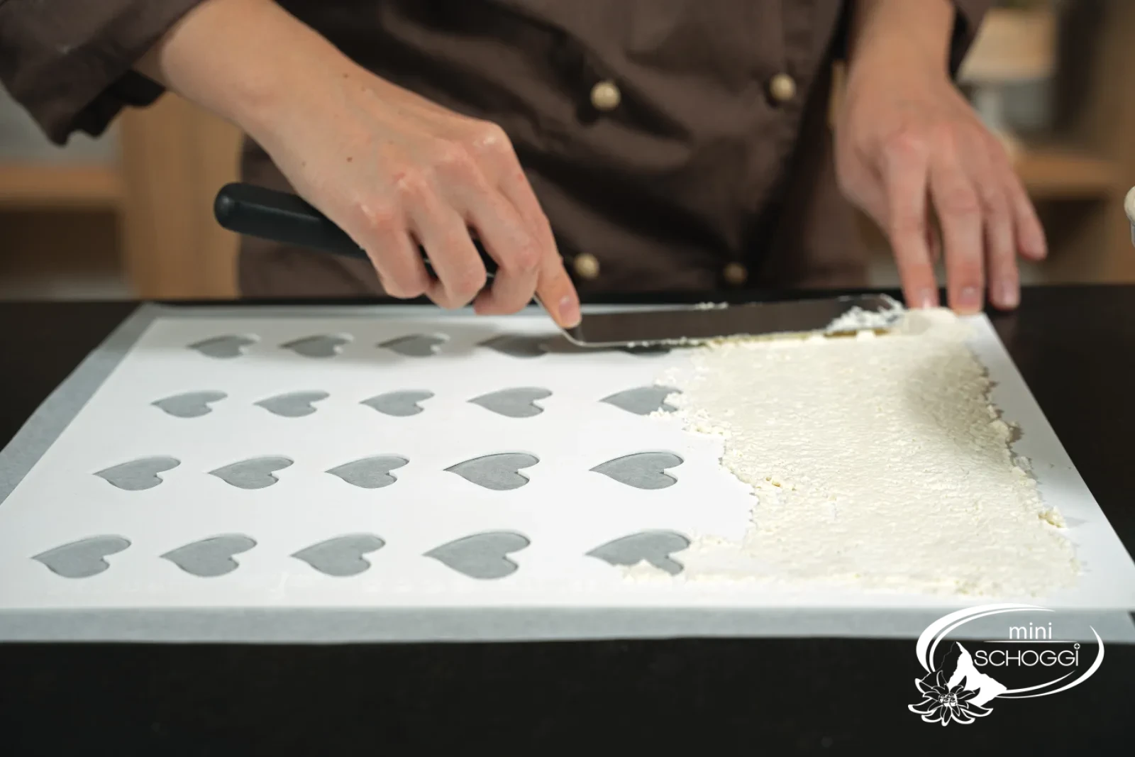 L'impasto al parmigiano viene steso attraverso lo stampo con la spatola angolata