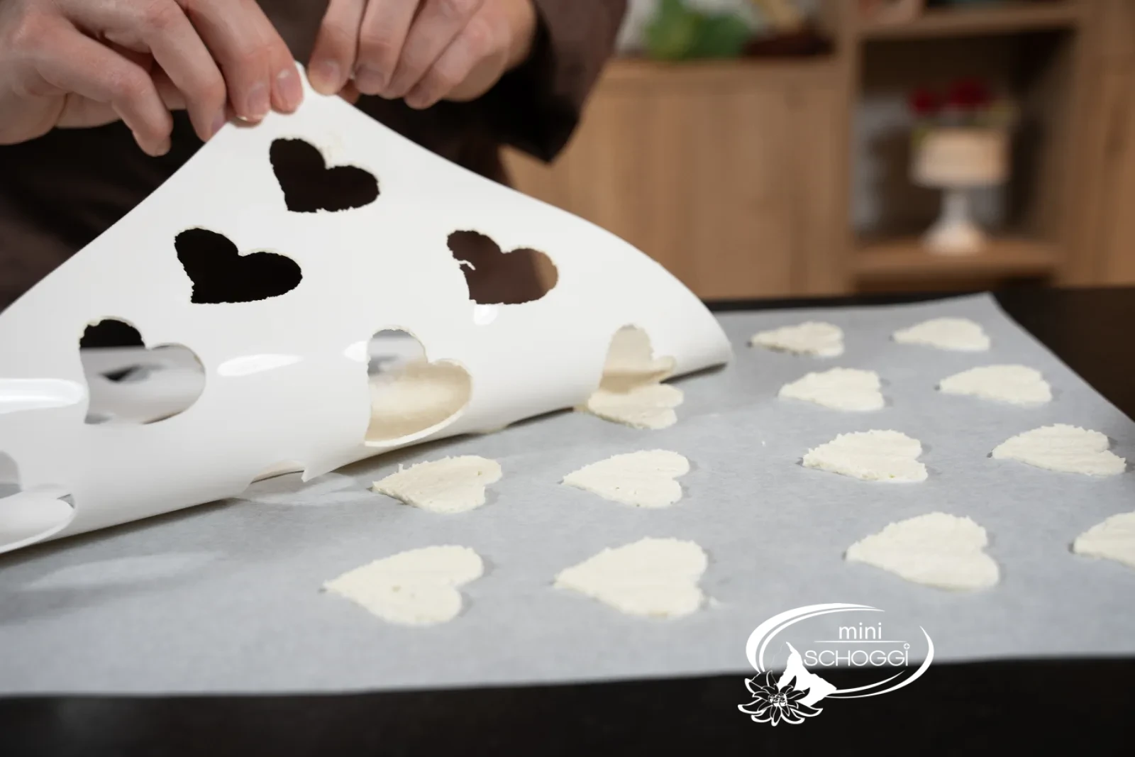Lo stampo viene sollevato, i cuori restano sulla carta da forno
