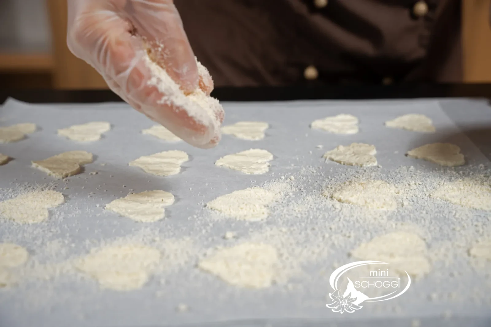 Il parmigiano grattugiato viene cosparso abbondantemente sulle chips stese