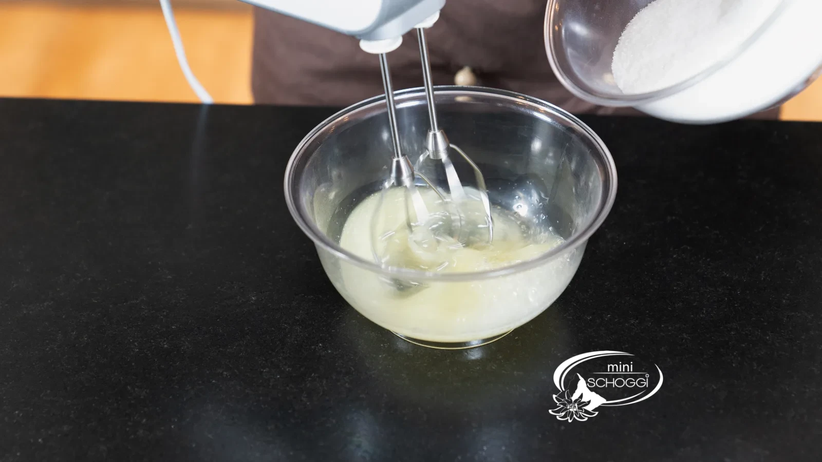 Des blancs d'œufs sont battus avec une pincée de sel dans un bol en verre