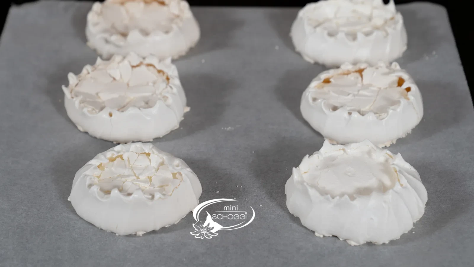 Des nids de meringue terminés et séchés avec un bord légèrement doré sur la plaque