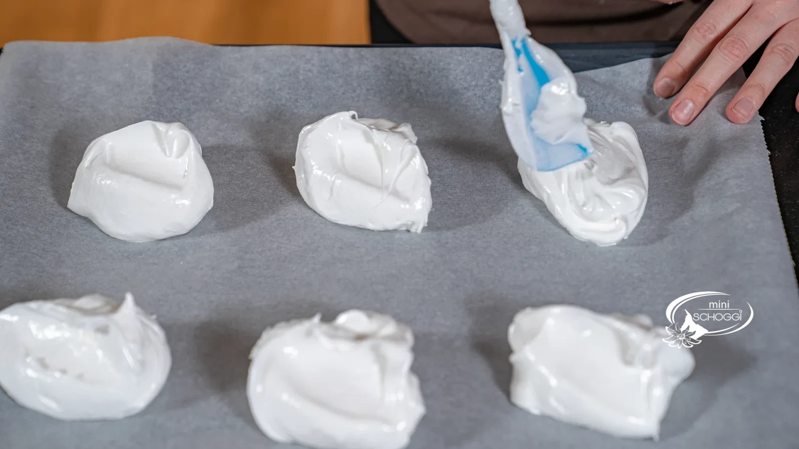 Des portions de masse de meringue sont déposées avec la Spatule sur le papier cuisson