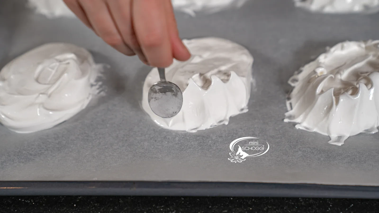 Le bord de la meringue est relevé vers le haut à l'aide d'une cuillère