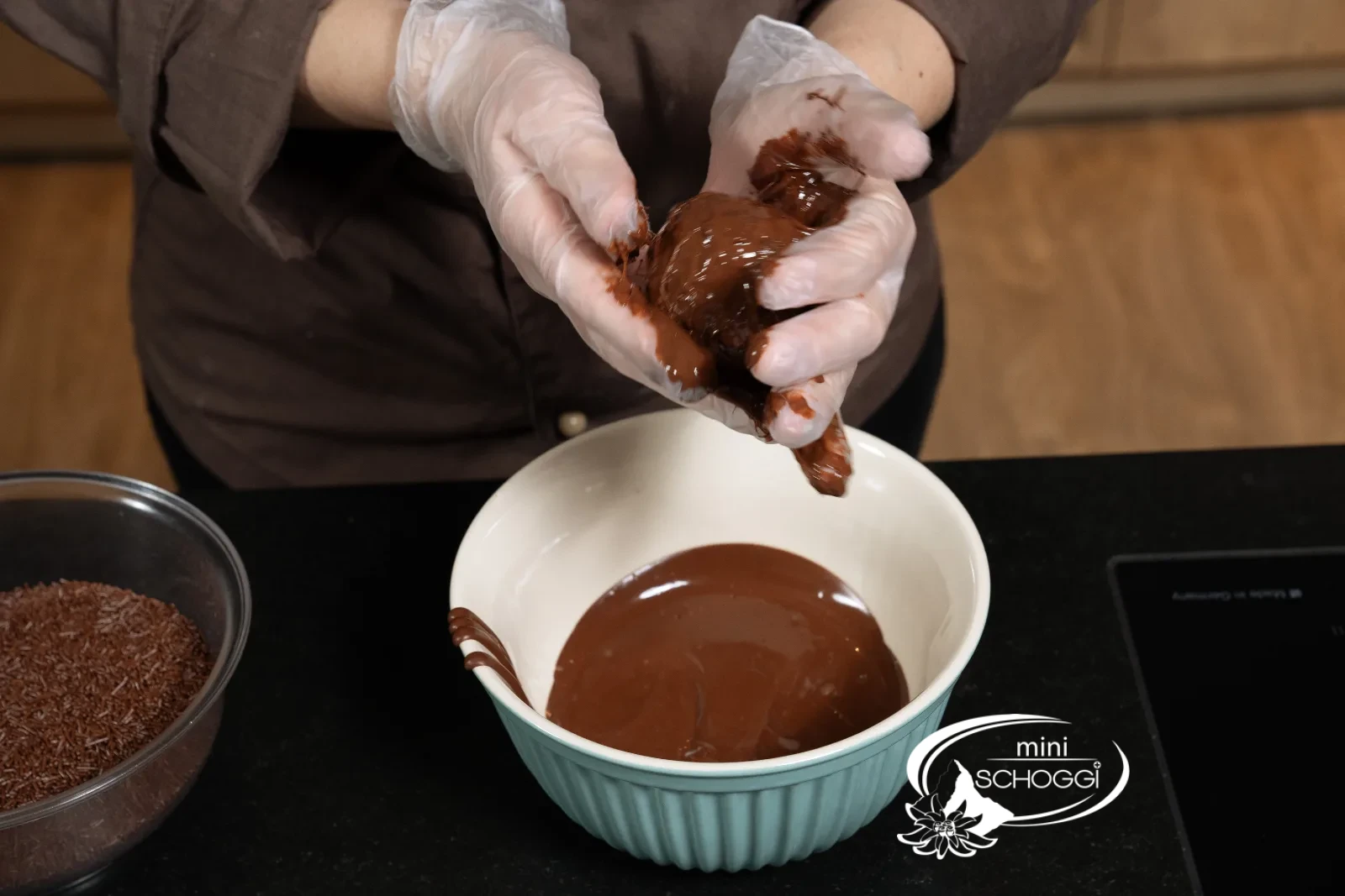 Une boule de rhum est trempée dans le chocolat liquide