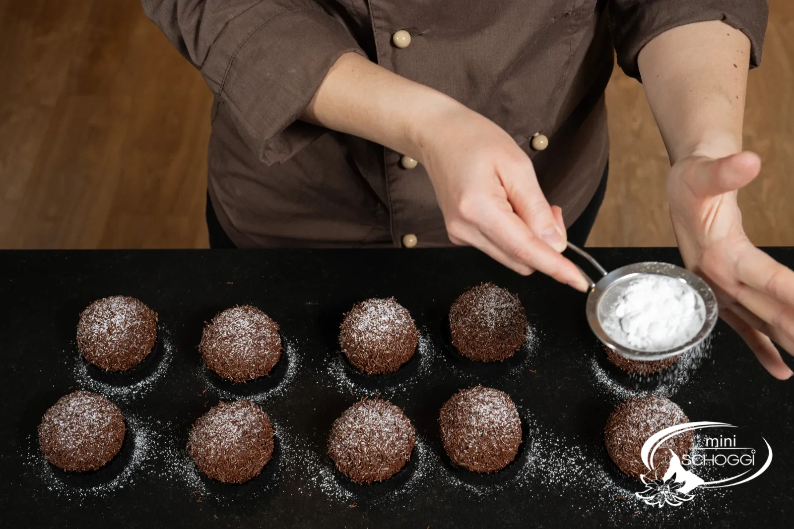 La neige sucrée est saupoudrée sur les boules à l'aide du Tamis