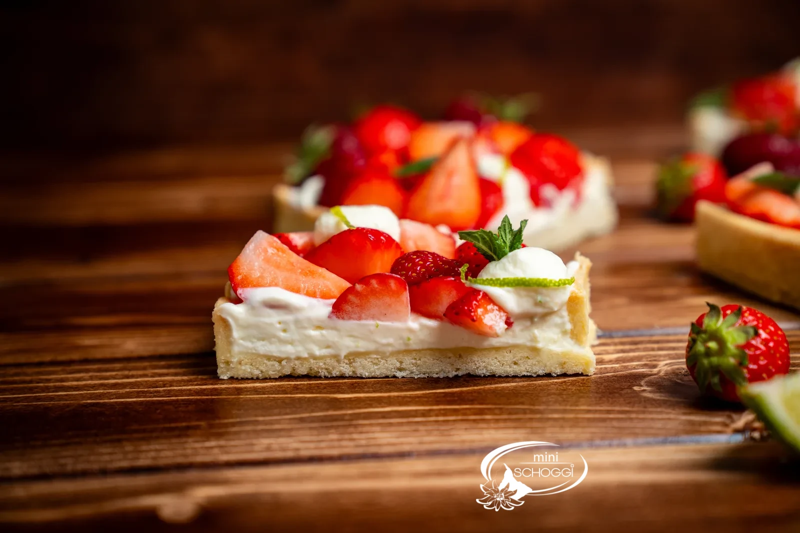 Quark-Tarte mit Creme-Tuffs, frischen Beeren, Limettenabrieb und Minze auf einer Tortenplatte