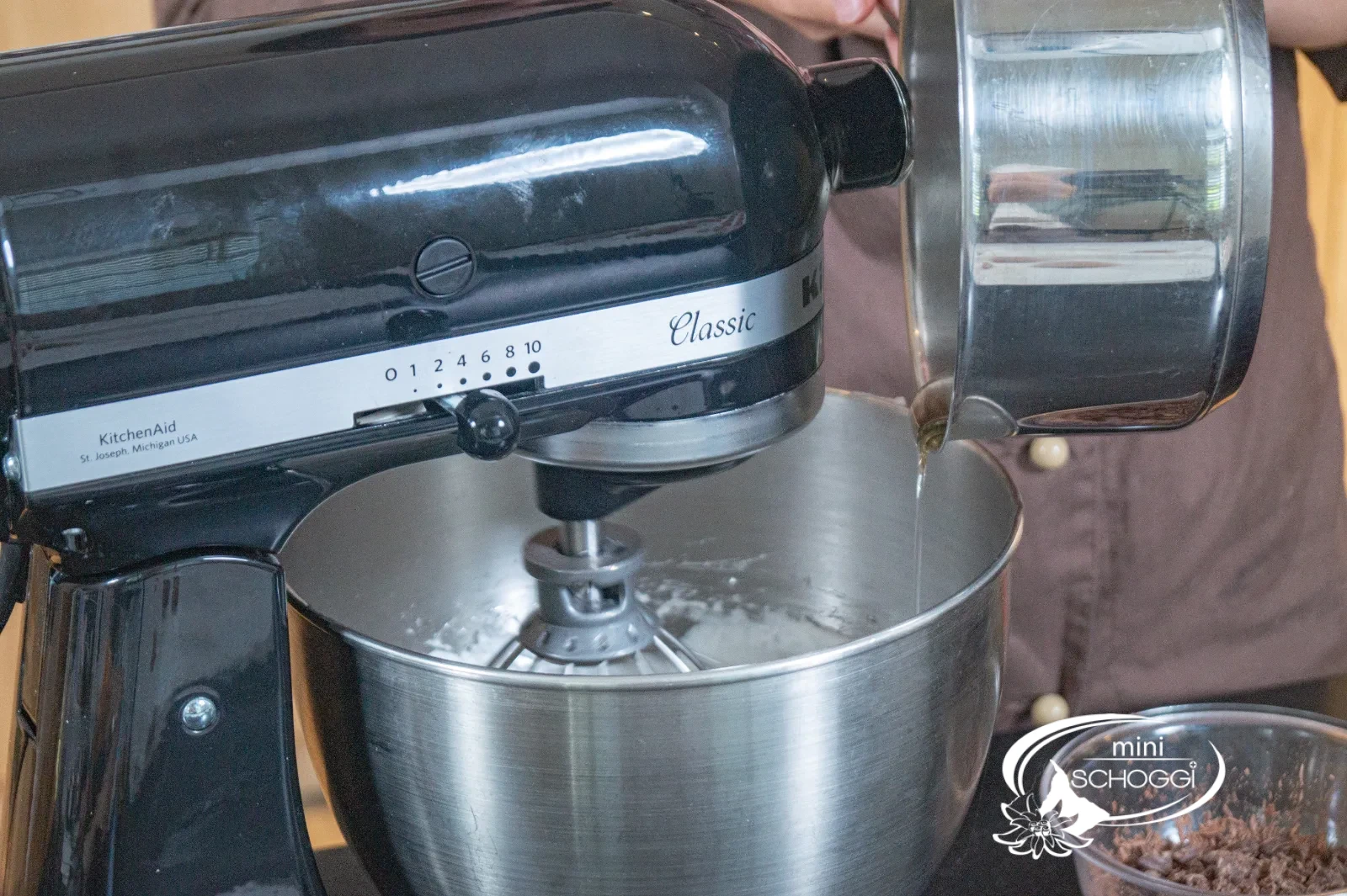 Le sirop de sucre chaud s'écoule en un mince filet dans la masse de meringue
