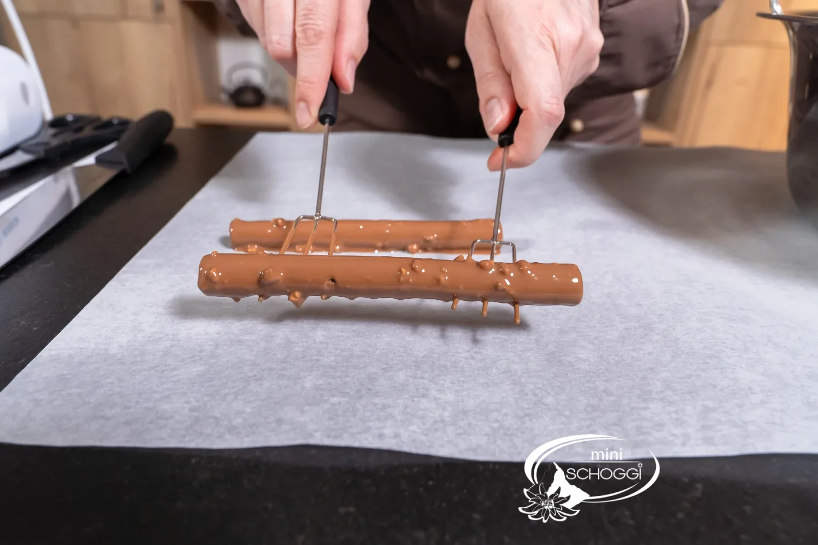 The freshly coated chocolate twigs are set down on baking paper
