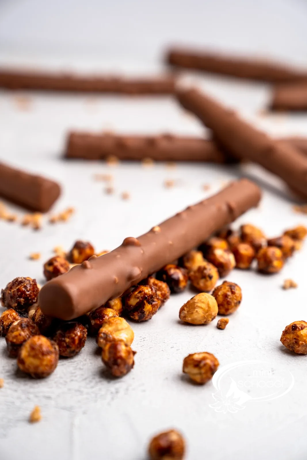 Homemade chocolate twigs with Hazelnut brittle next to caramelised hazelnuts