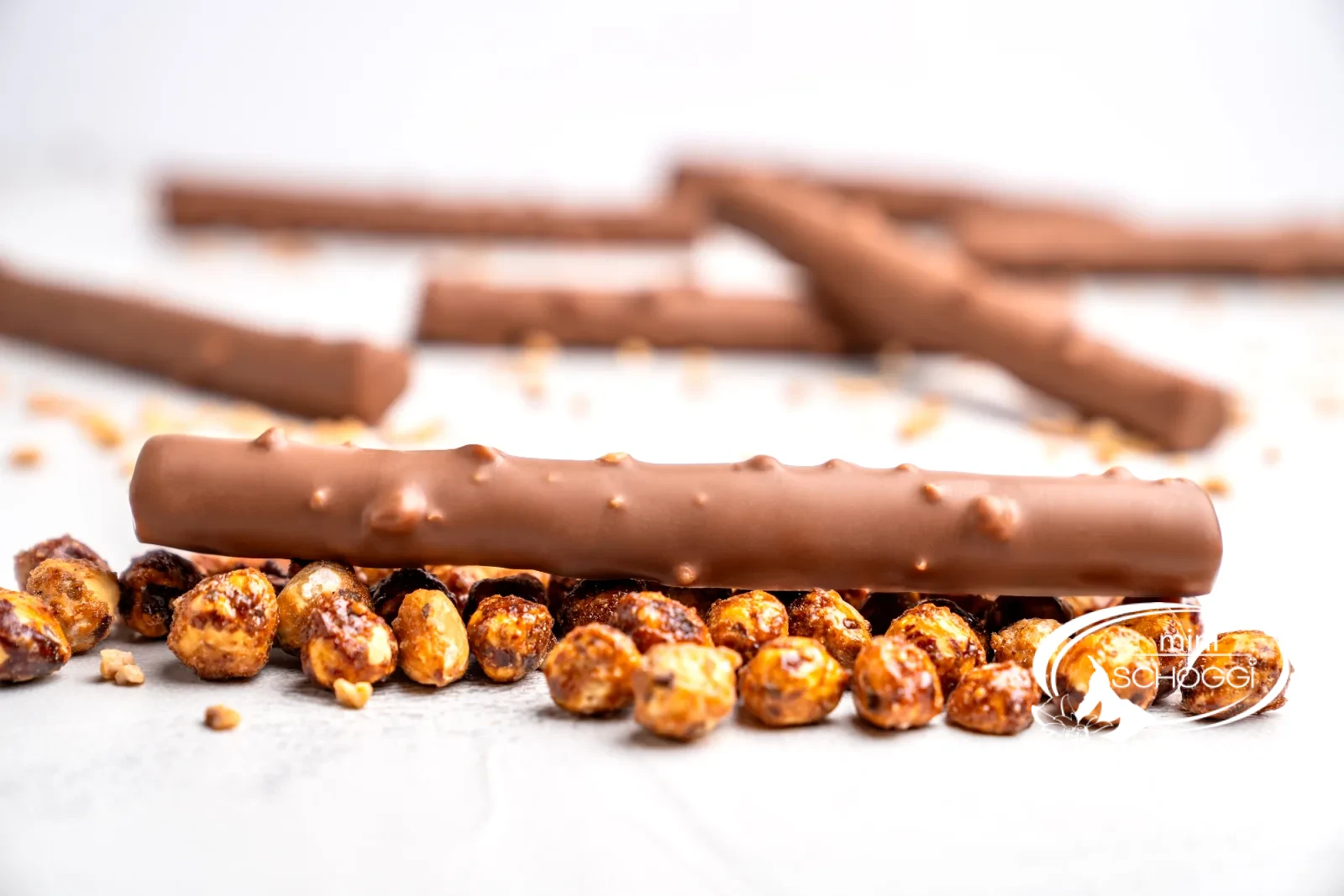 Homemade chocolate twigs with Hazelnut brittle next to caramelised hazelnuts