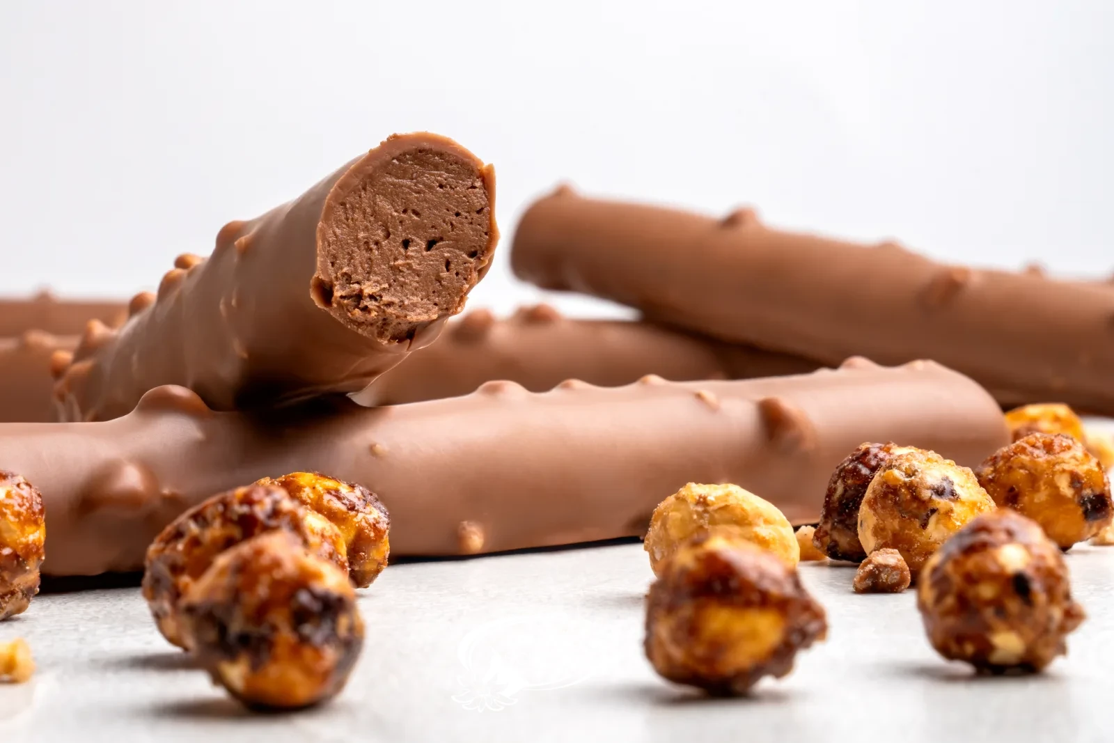 Homemade chocolate twigs with Hazelnut brittle next to caramelised hazelnuts