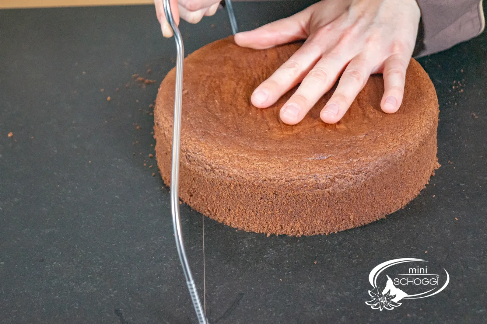 Il pan di Spagna al cioccolato viene staccato dall'anello per torta con la spatola