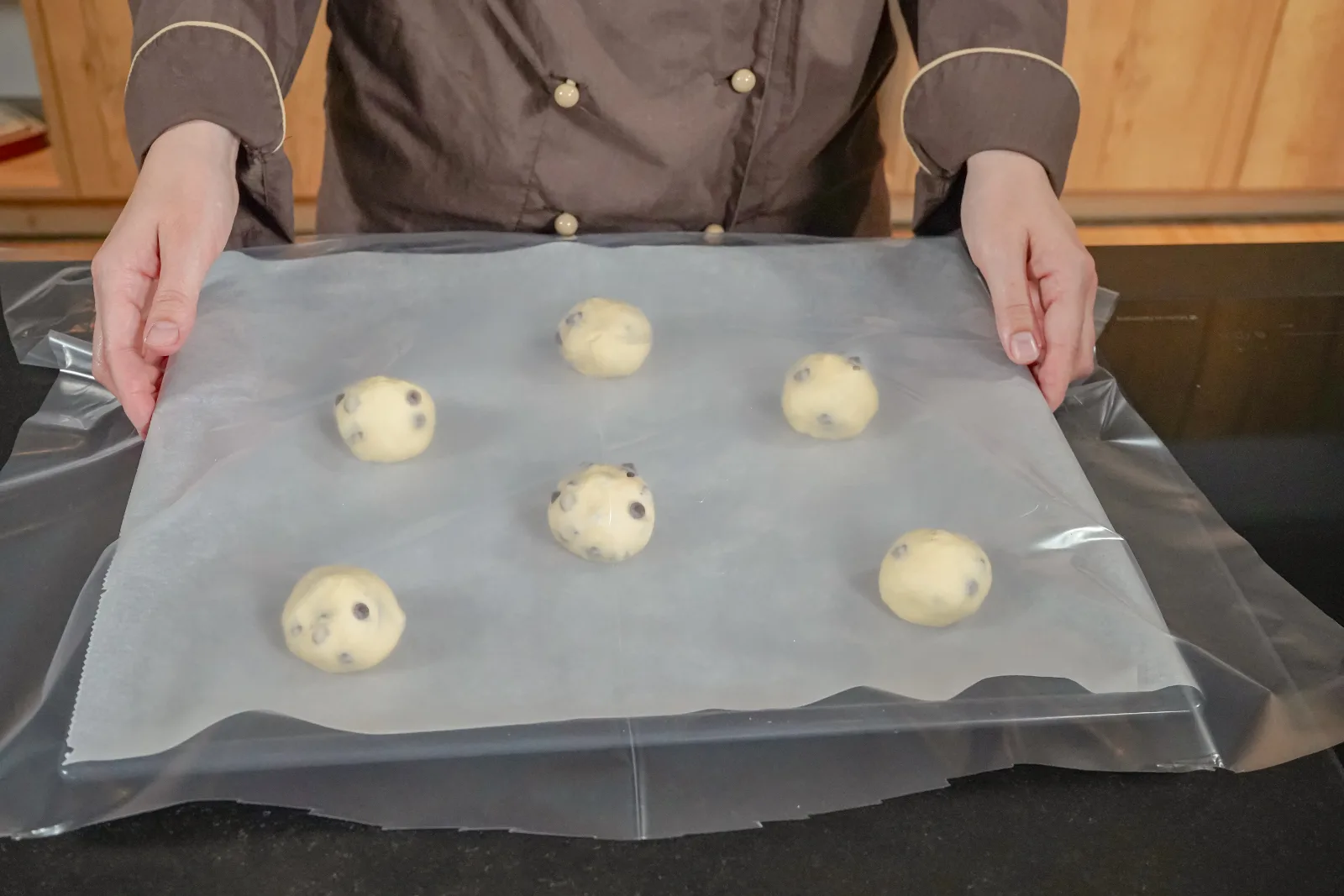 I pain au chocolat formati lievitano coperti sulla teglia