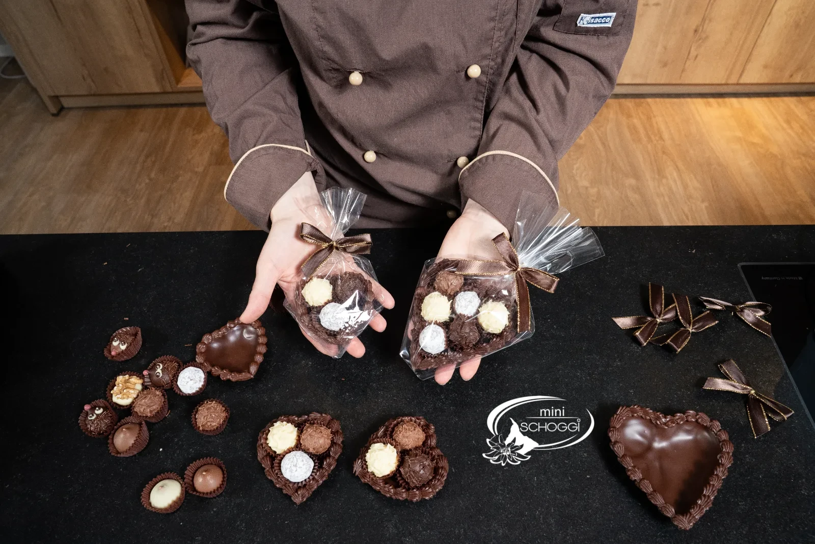 Due cuori di cioccolato confezionati nel sacchetto trasparente tra le mani