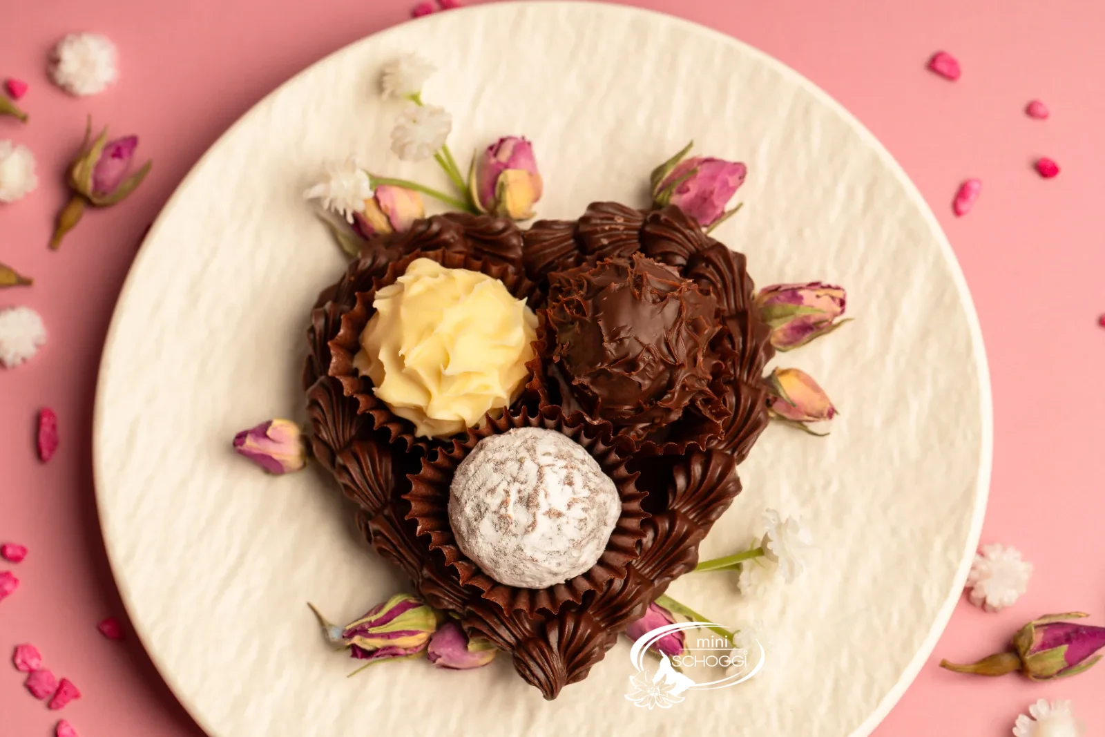 Cuori di cioccolato riempiti di Truffes, uno confezionato in sacchetto trasparente, su legno scuro