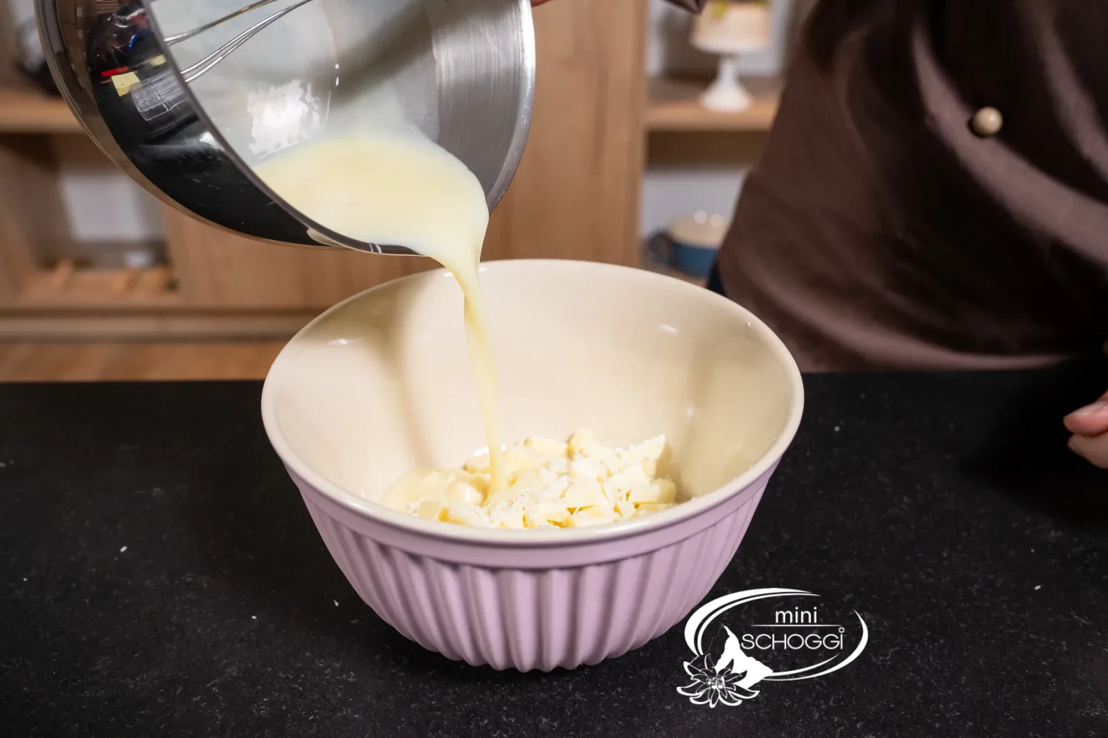 The hot milk mixture is poured over the chopped couverture