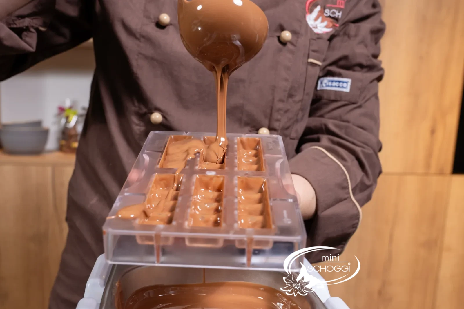 The tempered Milk couverture is poured into the bar mold