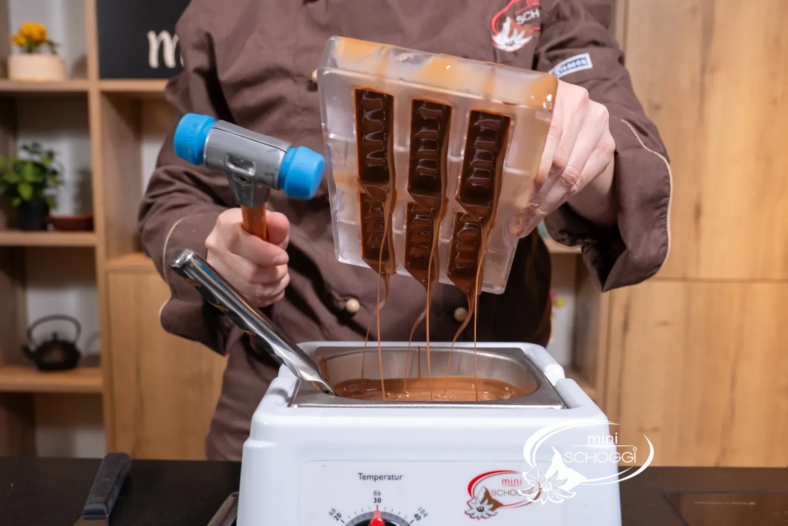 The excess couverture flows upside down back into the tempering device