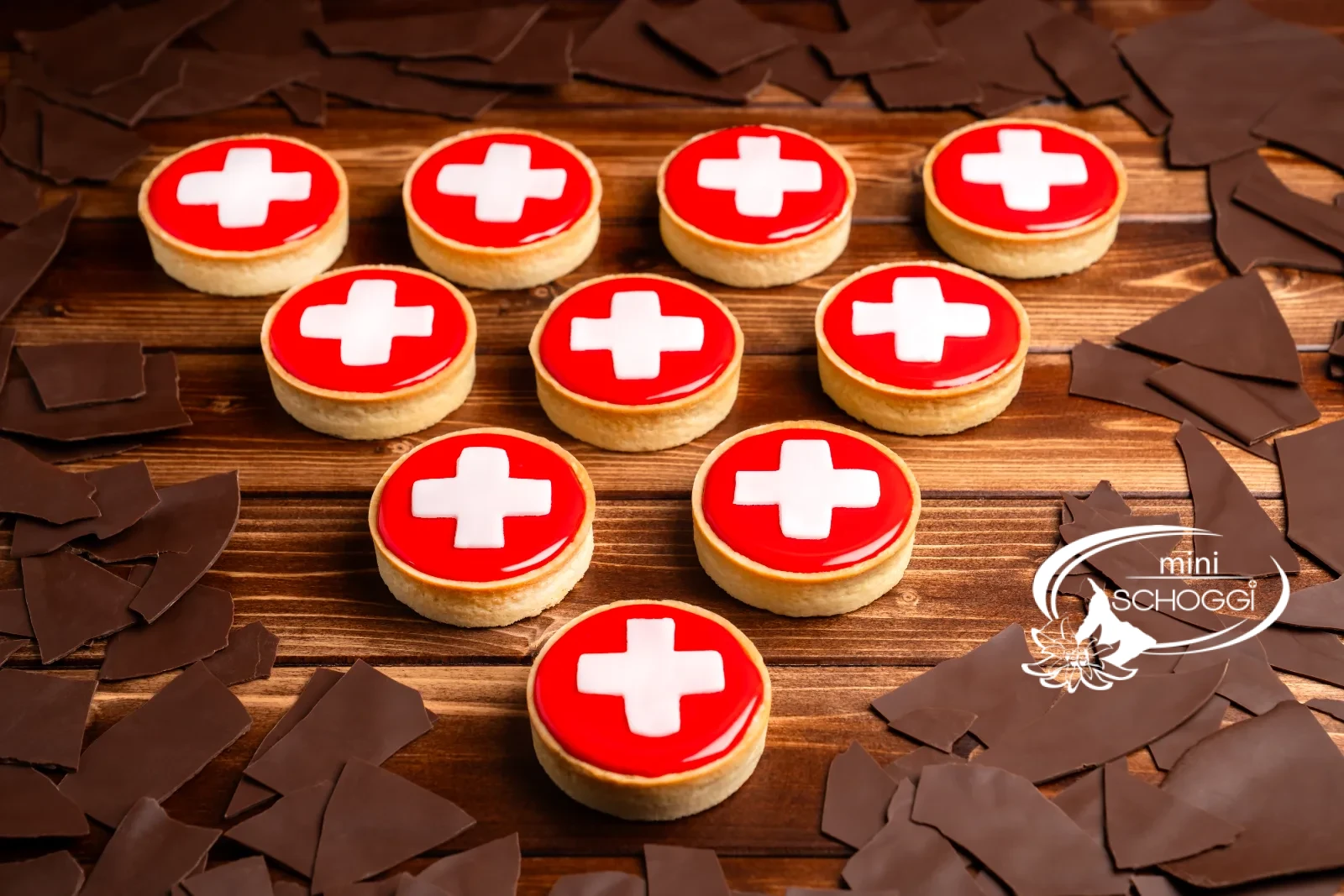 Carac svizzeri con fondant rosso e croce bianca su tavolo di legno scuro
