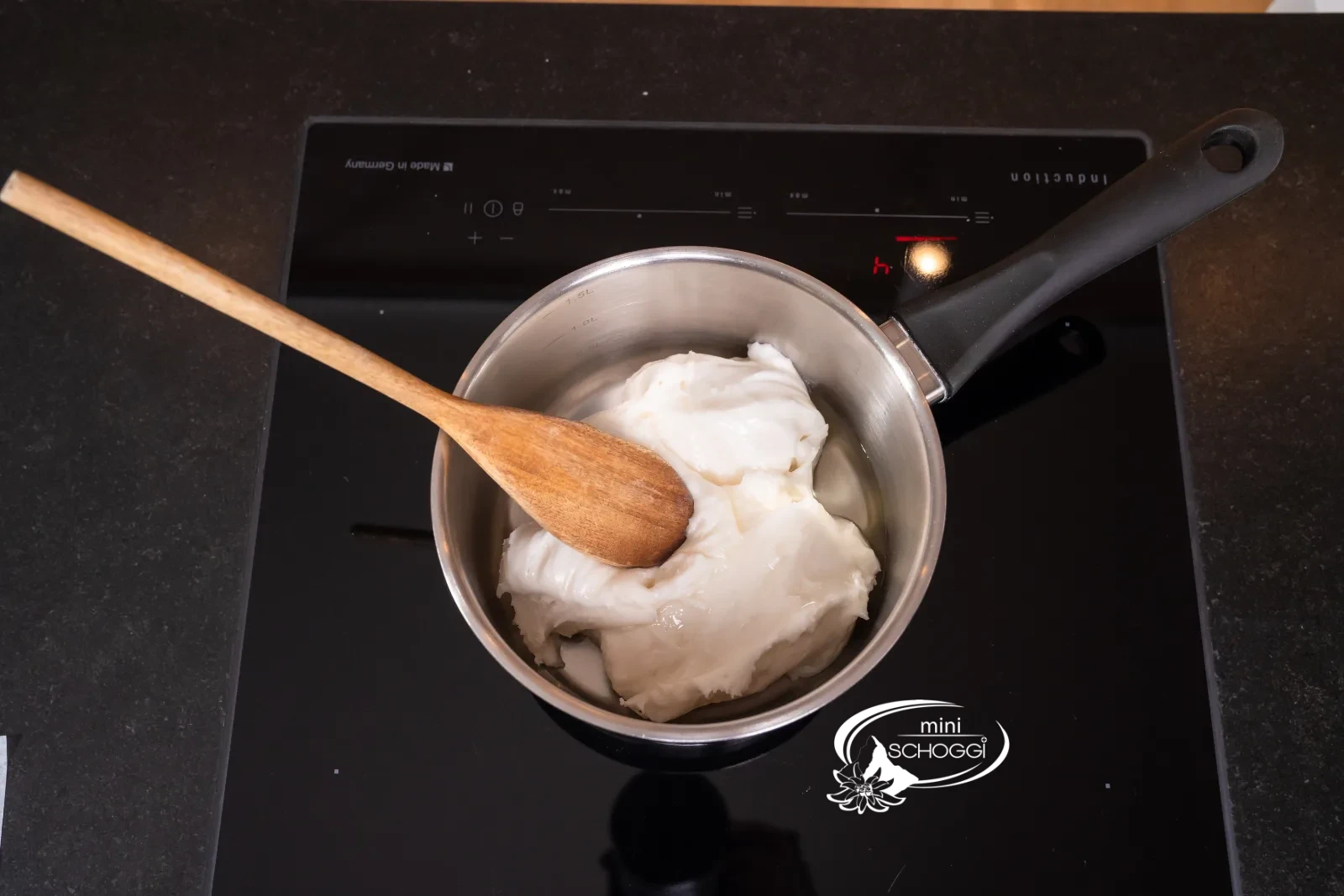 Fondente morbido bianco denso in pentola con mestolo di legno