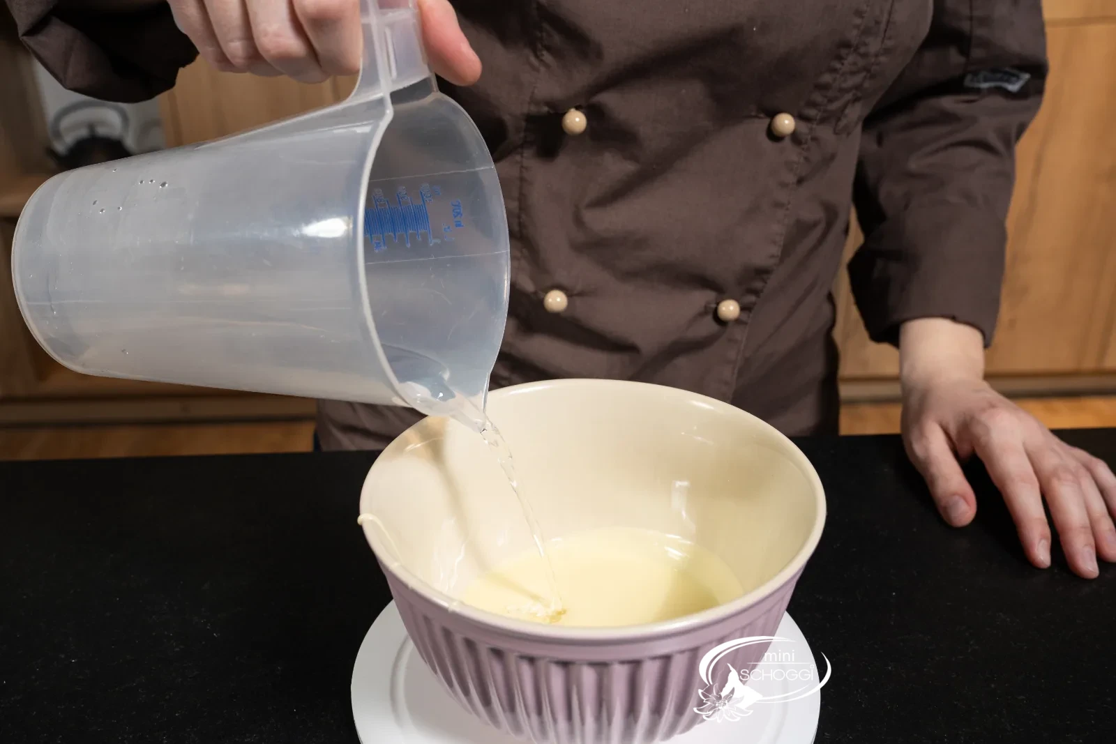 L'acqua calda viene aggiunta al cioccolato bianco sciolto