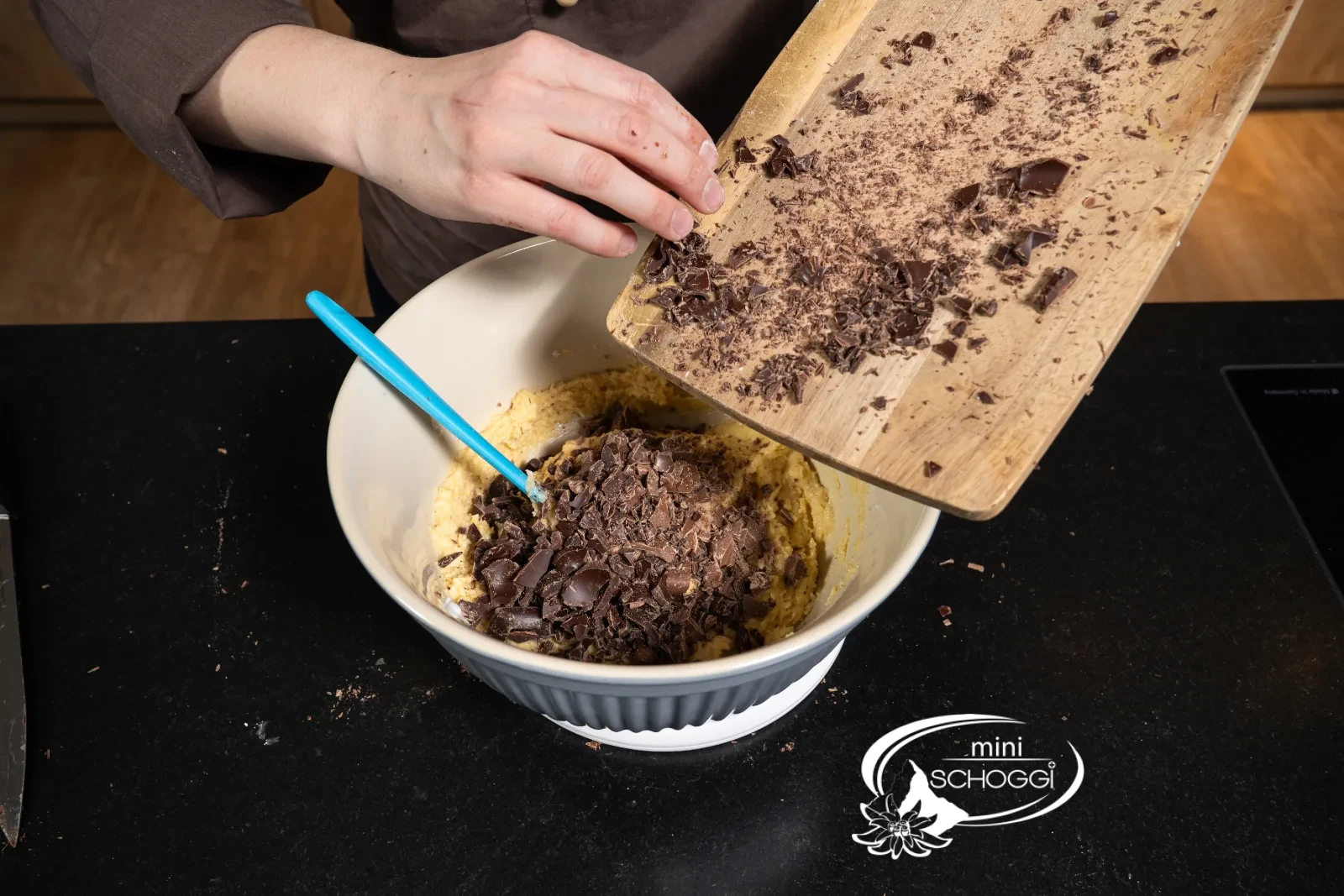 I pezzetti di cioccolato tritati scivolano dal tagliere nell'impasto