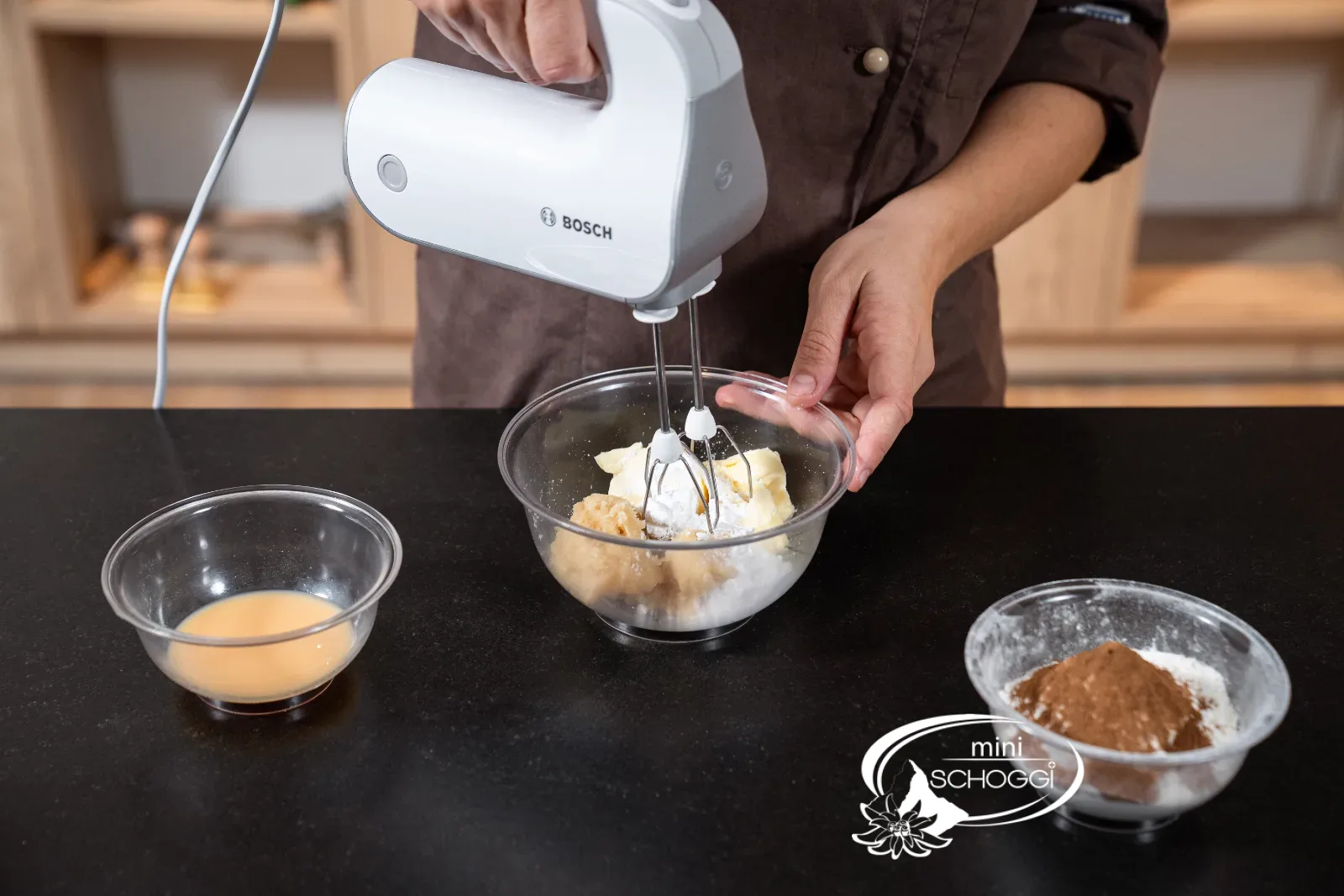 Battre le beurre, la pâte d'amande et le sucre glace en crème avec le mixeur à main