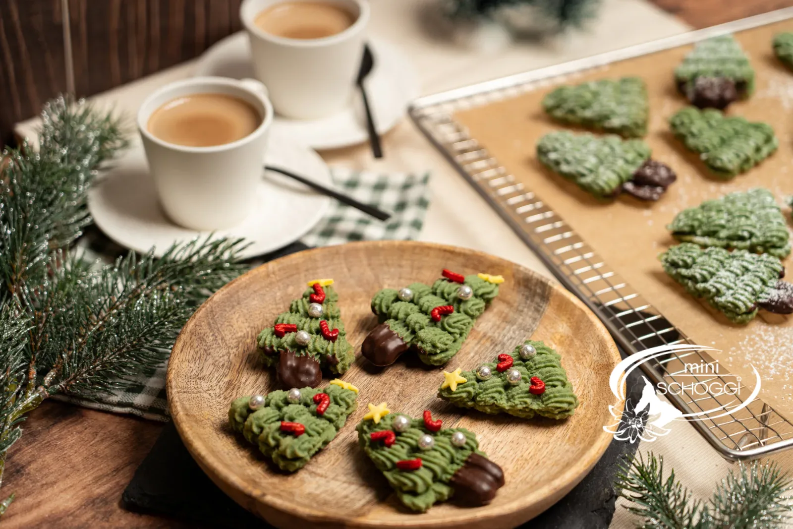 Plateau en bois avec sapins décorés et grille à gâteau avec petits sapins en sucre glace