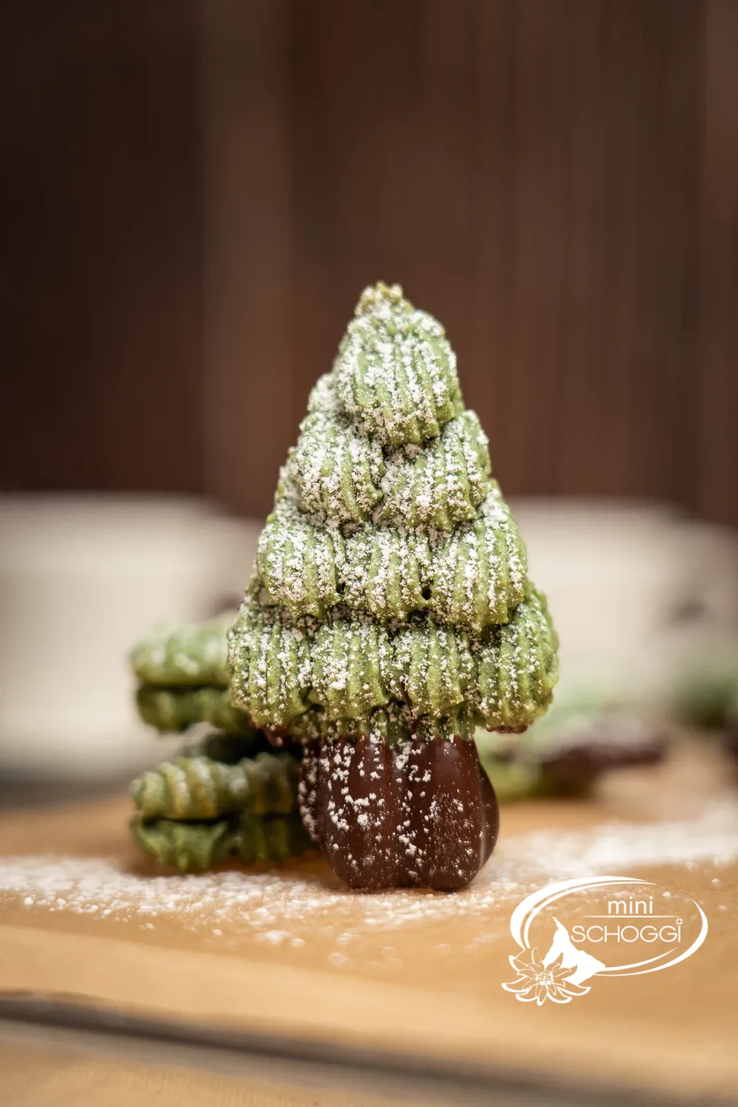 Sapin debout en biscuit en spritz saupoudré de sucre glace avec tronc en chocolat