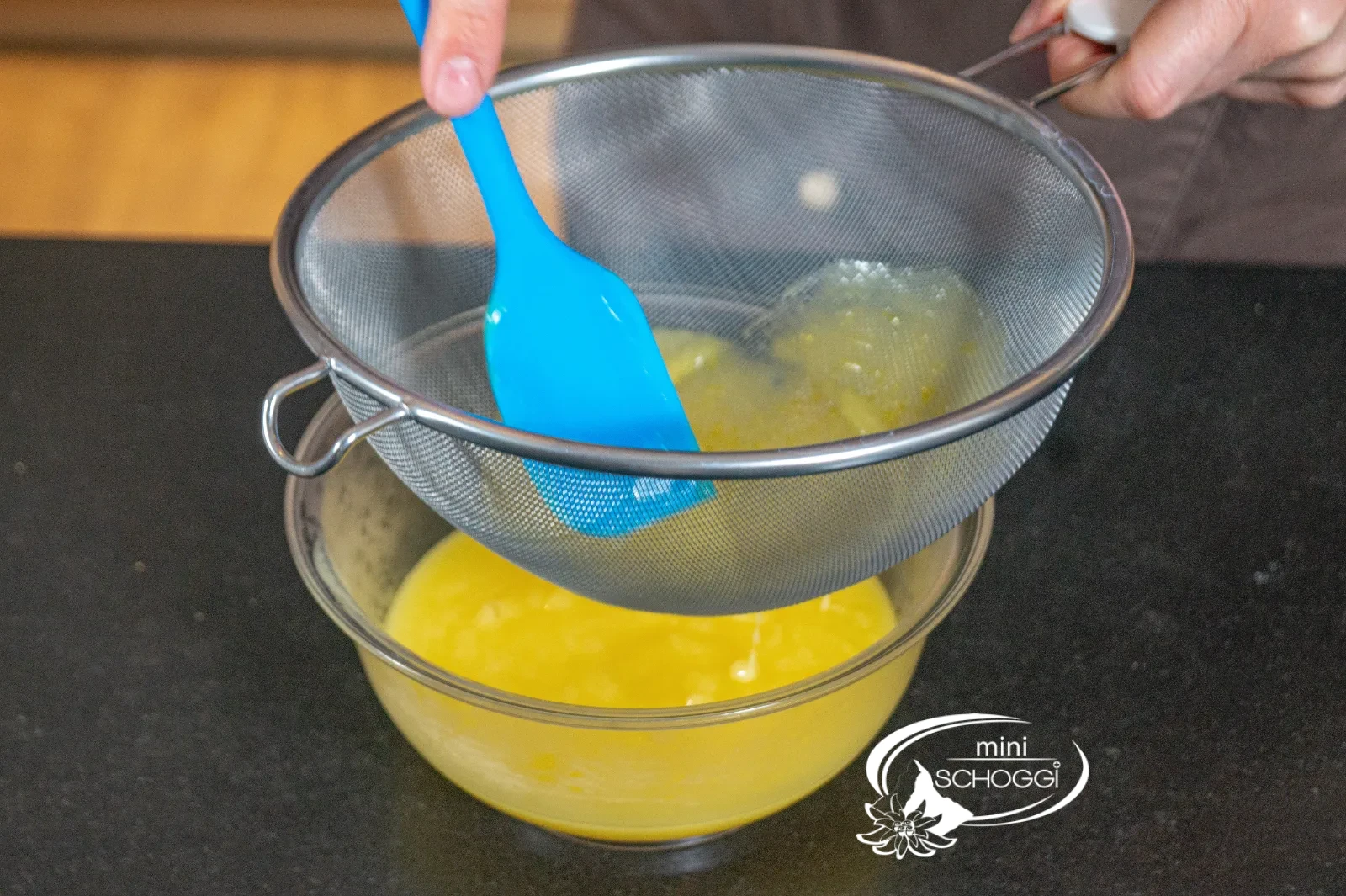 La crema al limone viene passata con una spatola attraverso un setaccio in una ciotola