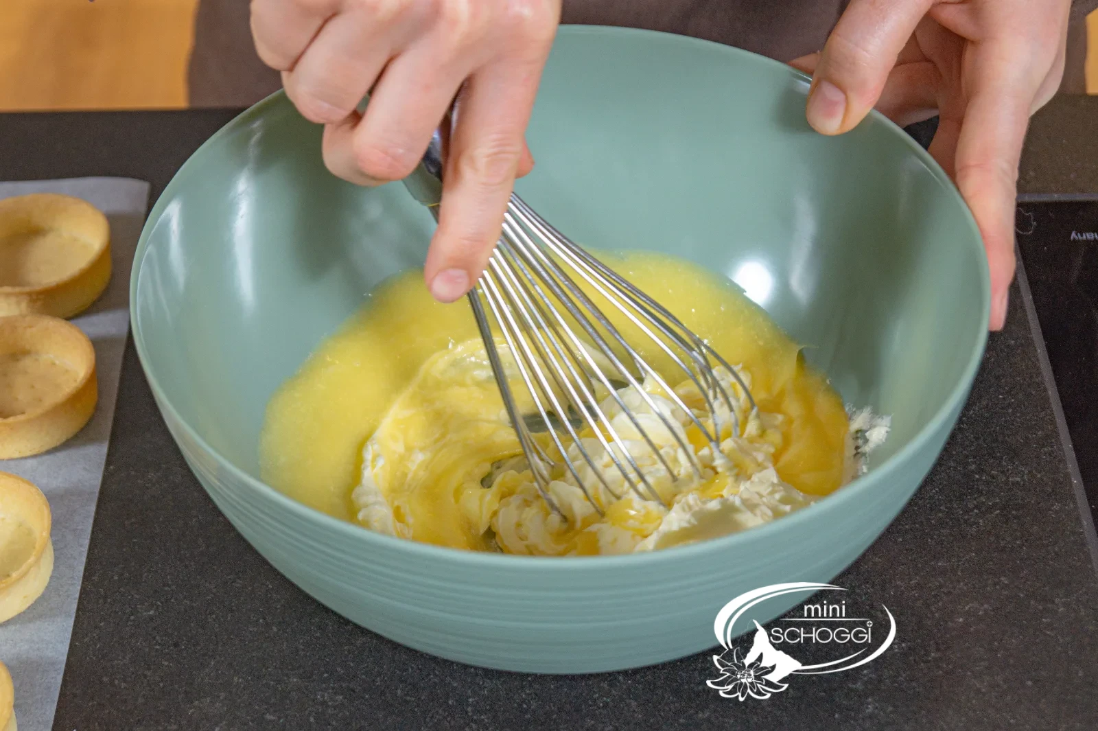 La crema al limone e la crema al burro vengono mescolate in una ciotola con la frusta