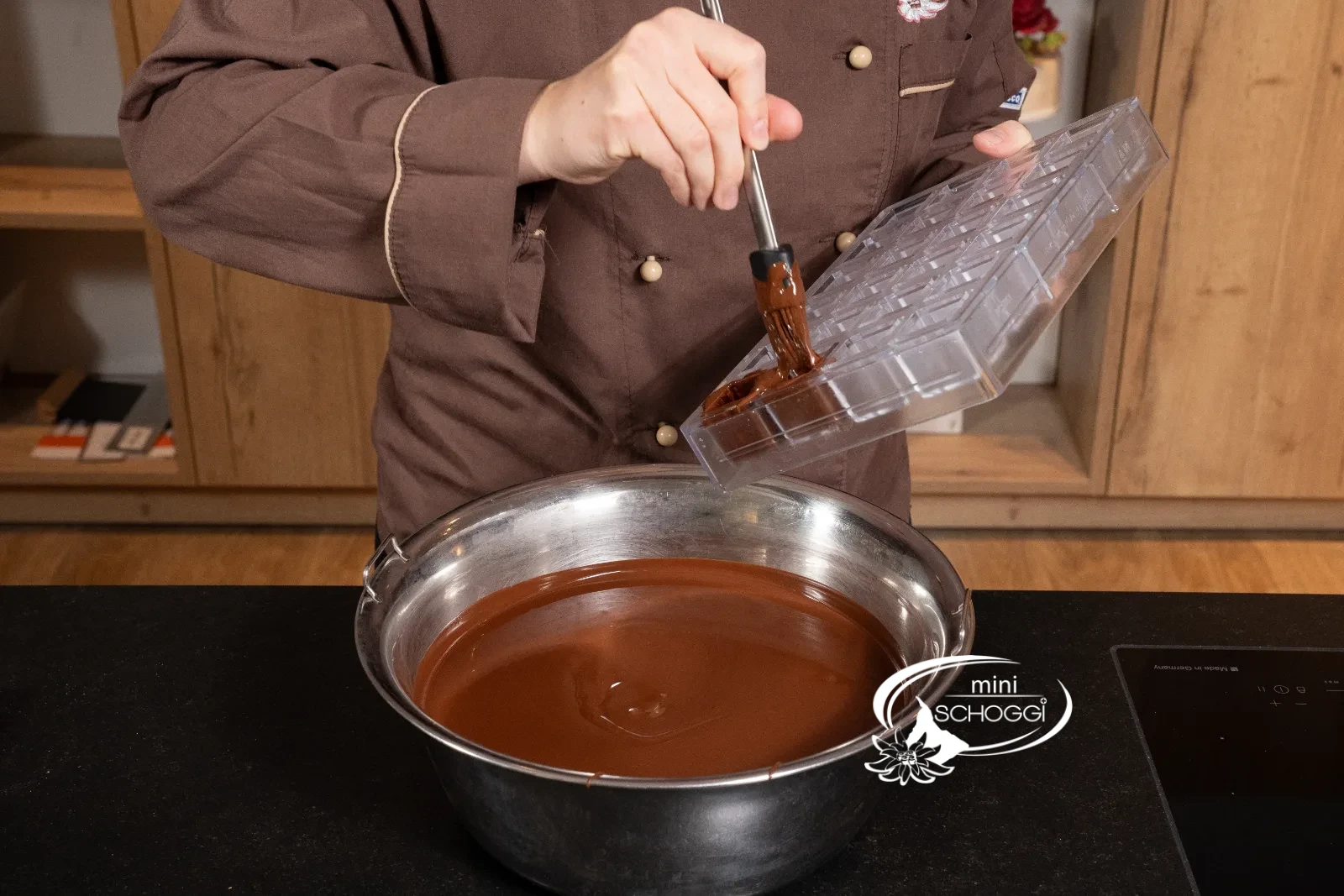 Die Würfel der Form werden mit temperierter Couverture ausgepinselt