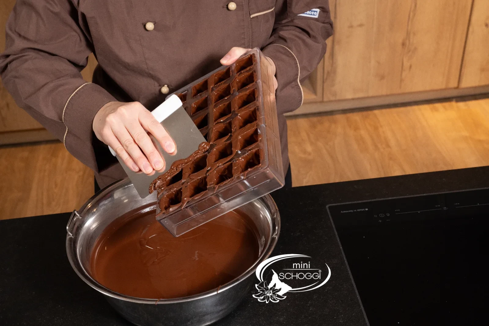 Die Würfel der Form werden mit temperierter Couverture ausgepinselt