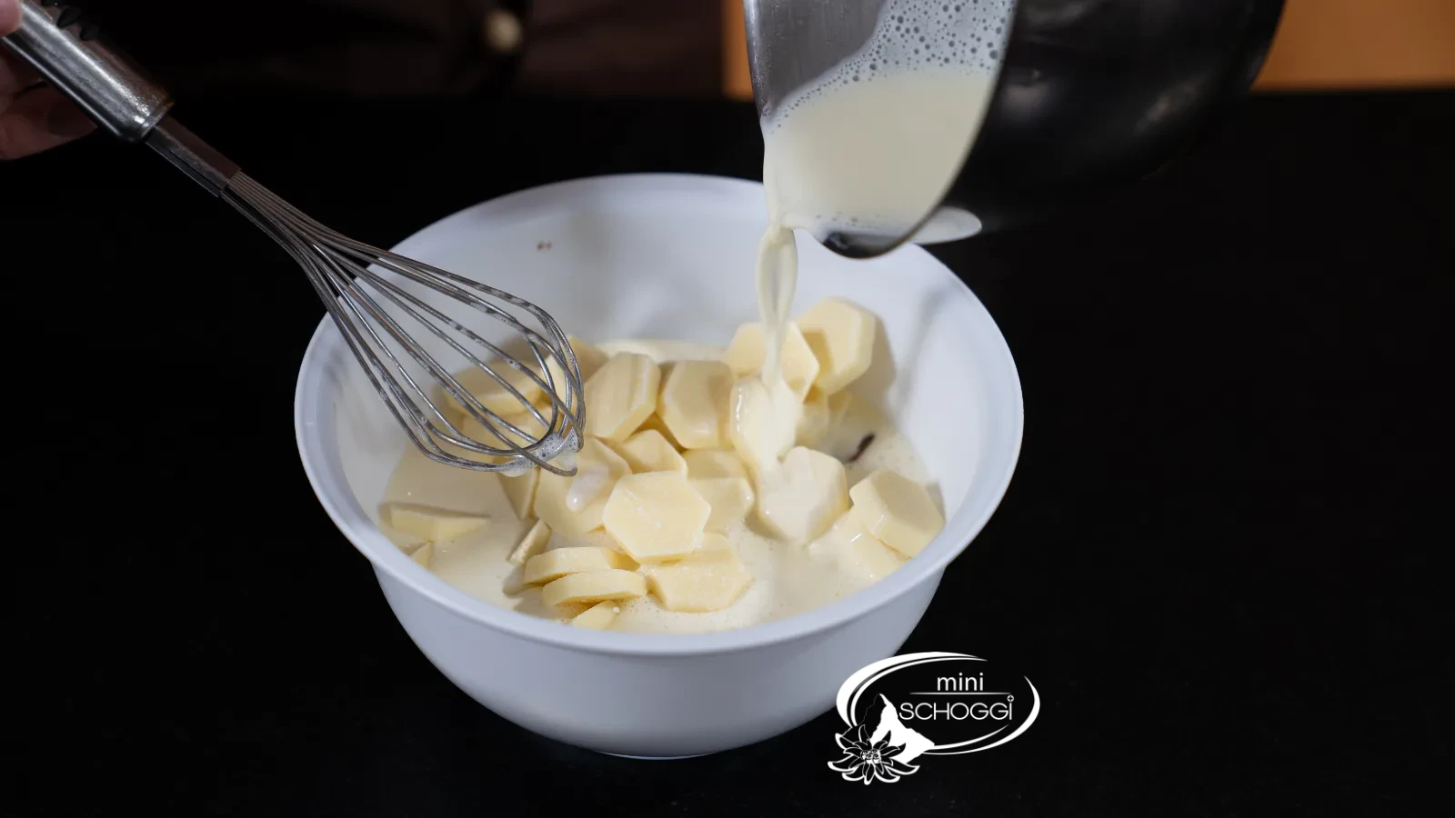 La crème chaude est versée sur le Chocolat blanc