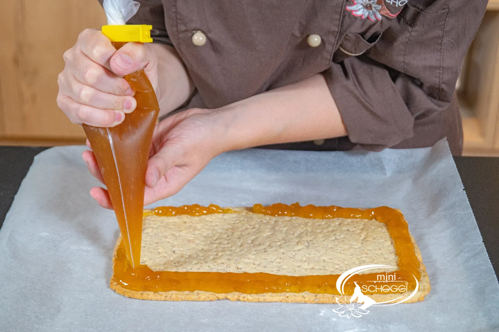 La confettura di albicocche viene spalmata uniformemente sulla base del waffel