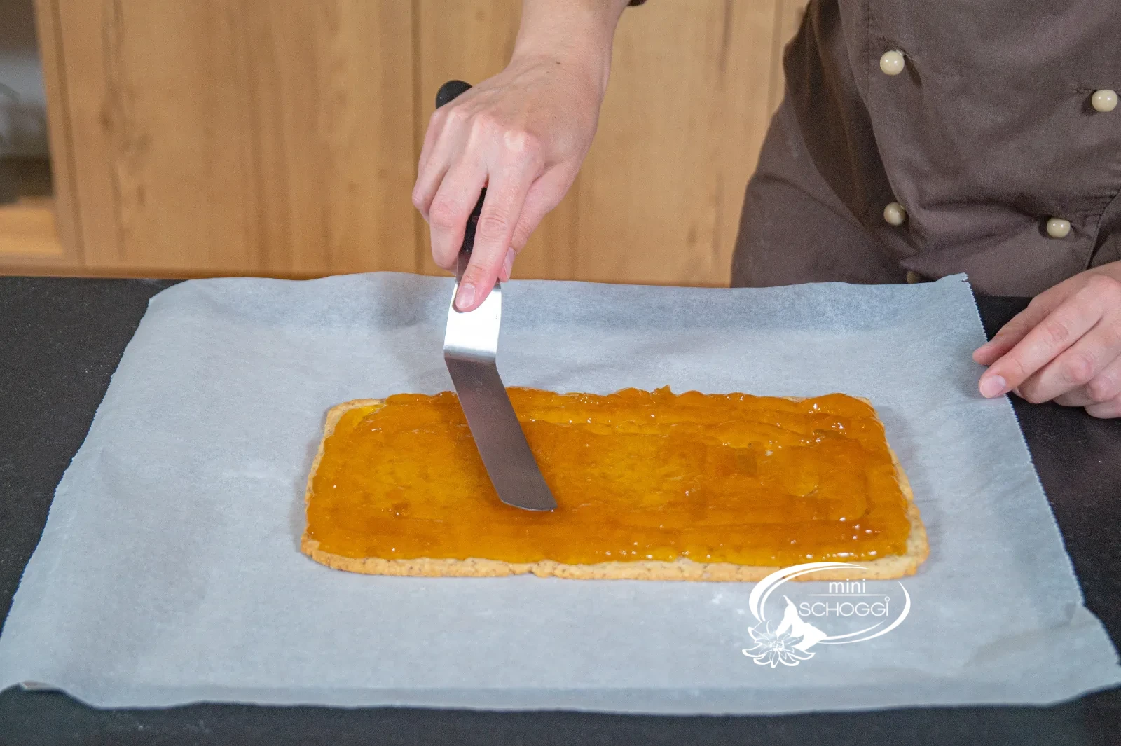 La confettura di albicocche viene spalmata uniformemente sulla base del waffel