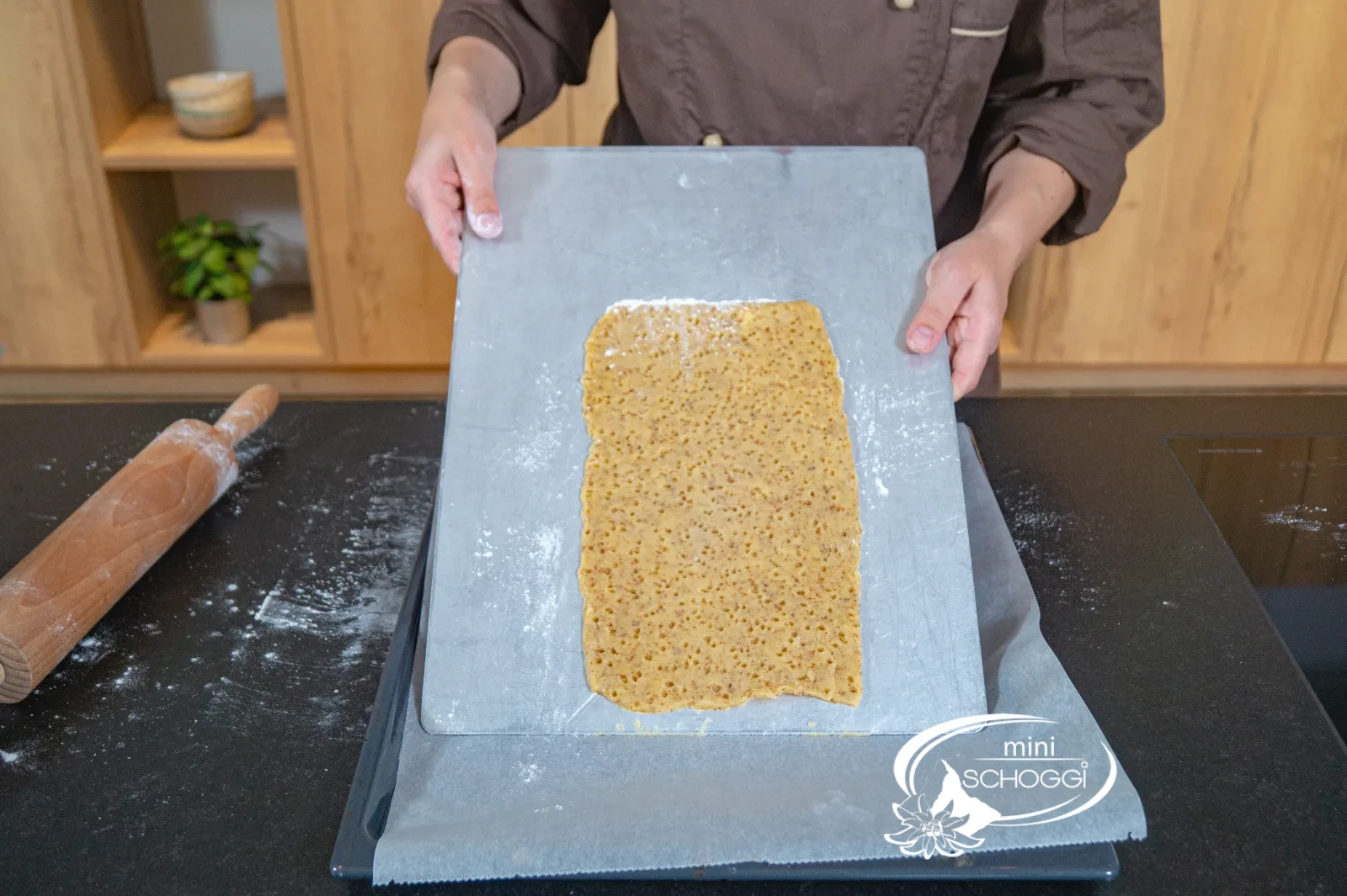 La sfoglia bucata viene sollevata con la Teglia per torte sulla Teglia