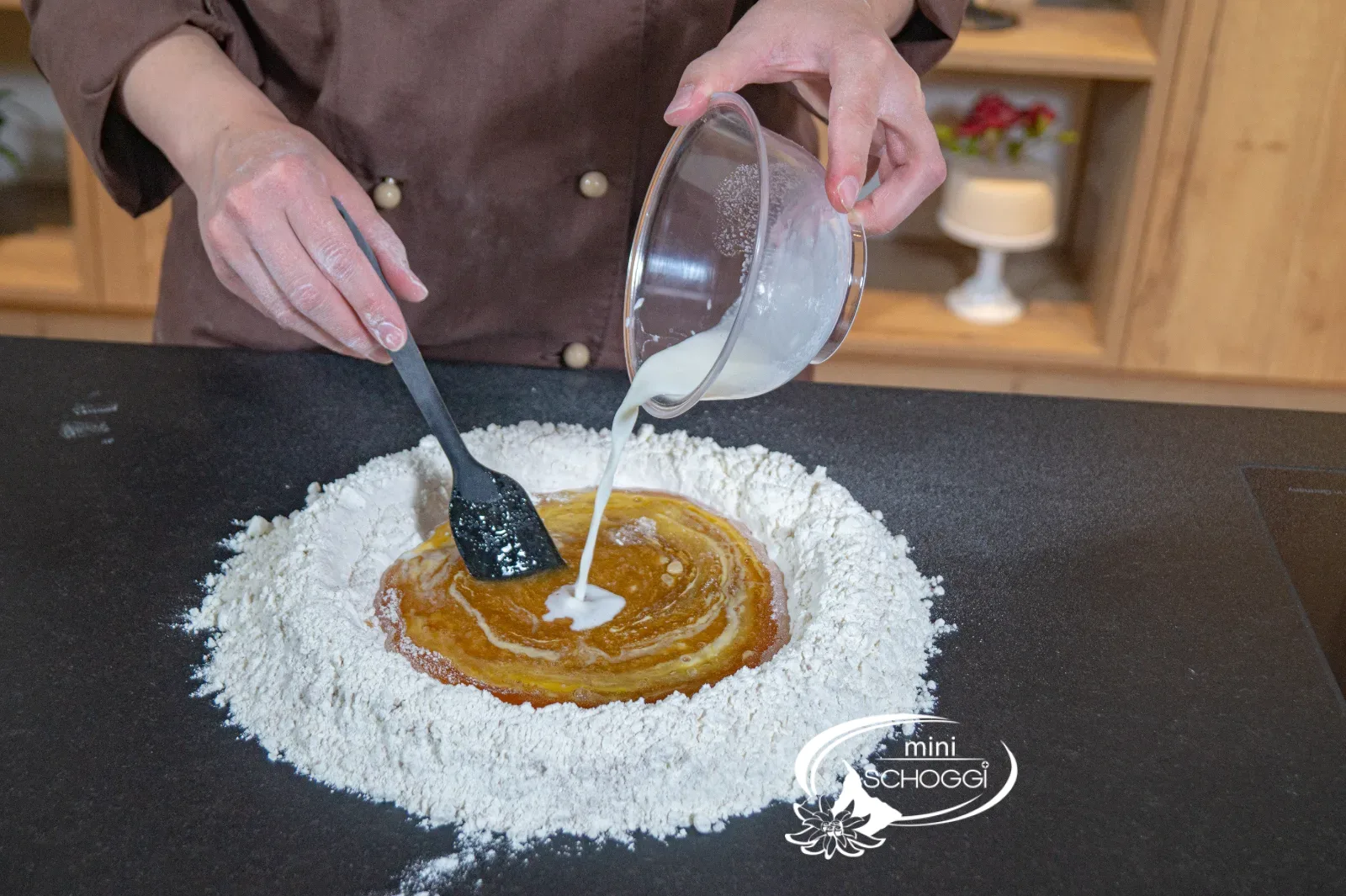 I lieviti sciolti vengono aggiunti alla massa di miele nella fontana di farina